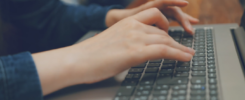 Image des mains d'un étudiant posées sur le clavier de son ordinateur