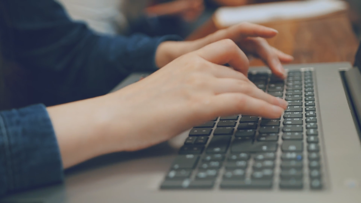 Image des mains d'un étudiant posées sur le clavier de son ordinateur