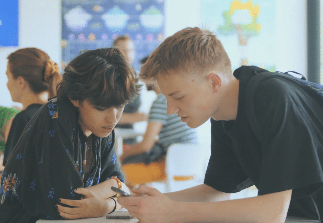 Photos de deux étudiants regardant leur téléphone.