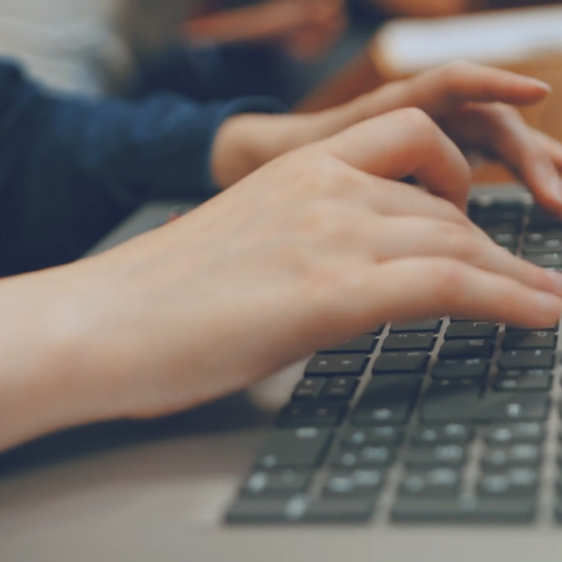 Image des mains d'un étudiant posées sur le clavier de son ordinateur